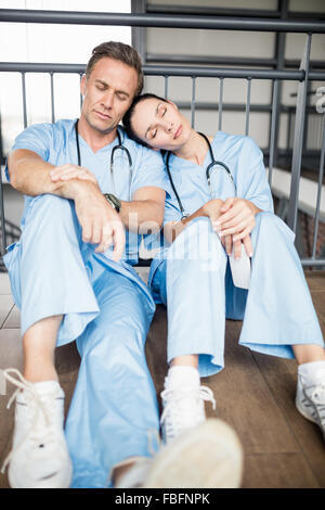 Stanco team medico di addormentarsi sul pavimento Foto Stock