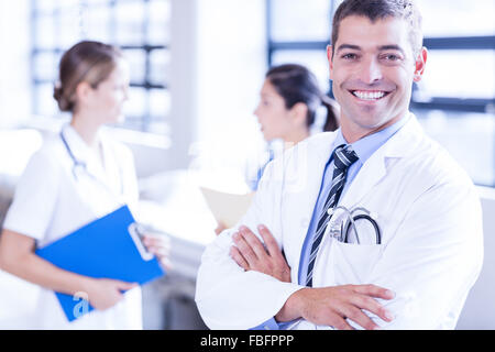 Medico maschio con bracci incrociati Foto Stock