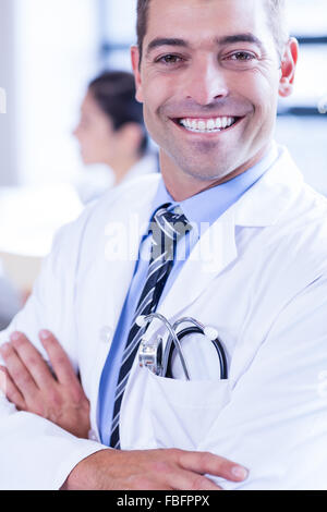 Medico maschio con bracci incrociati Foto Stock
