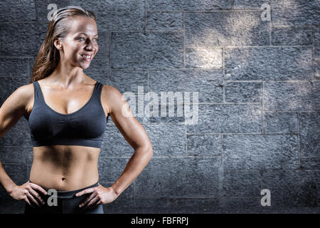 Immagine composita di allegro atleta con mani su hip Foto Stock