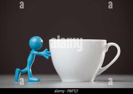 Blue man spingendo e tazza di caffè. Foto Stock