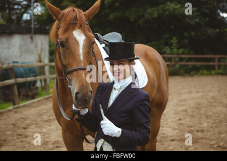 Jockey femmina portando il suo cavallo Foto Stock