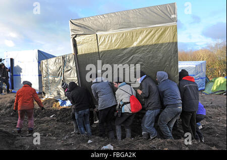 Jungle, Calais, Francia. Venerdì 15 Gennaio 2016. I volontari aiutano i profughi si muovono rifugi temporanei al di fuori della zona di demolizione. Foto Stock