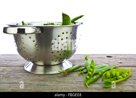 Appena raccolti cresciuti in casa di piselli organico in uno scolapasta Foto Stock