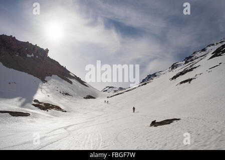 Gli alpinisti in salita per escursioni di sci alpinismo sul pendio nevoso verso il vertice della montagna. Concetto di conquista delle avversità e reachin Foto Stock
