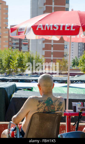 Turisti britannici che riporti il suo tatuato corpo superiore in shorts sono decorati con la Union Jack pub sulla terazza in un mercato settimanale Benid Foto Stock