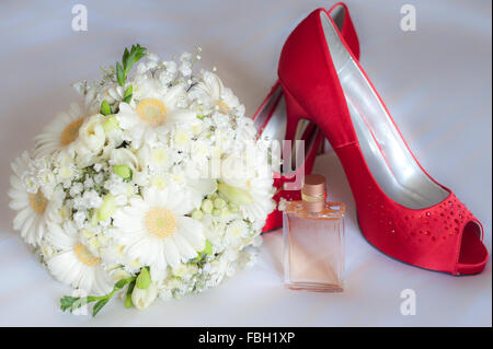 Sposa scarpe, bouquet e profumo su uno sfondo bianco. Foto Stock