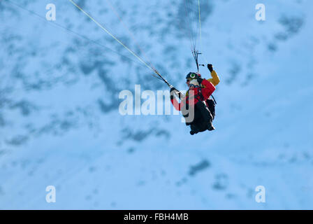 Pilota di parapendio in tandem con il vertiginoso aumento dei passeggeri su fianchi di Mt Blanc Foto Stock