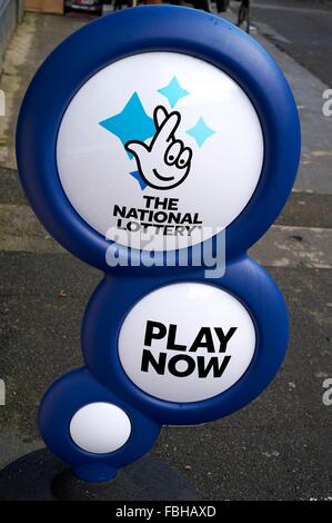 La lotteria nazionale gioca ora outdoor shop segno su una strada del regno unito Foto Stock
