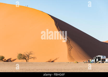 I turisti climbing dune di sabbia, Sossusvlei, Namib Desert, Parco Namib-Naukluft, Regione di Hardap, Repubblica di Namibia