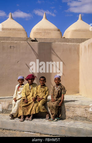 Jalan Bani Bu Ali, Oman. Pre-teen Omani ragazzi seduti al di fuori della moschea di Rashid bin Hamouda, Jalan Bani Bu Ali. Foto Stock