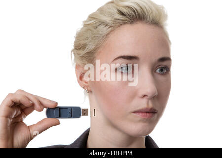 La donna in un business suit tenendo un memory stick di metterlo nel suo collo Foto Stock