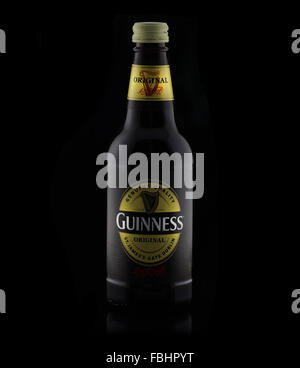 Una bottiglia di birra Guinness su uno sfondo nero Foto stock - Alamy