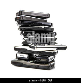 Pila di vecchi telefoni cellulari pronto per il riciclaggio su sfondo bianco Foto Stock