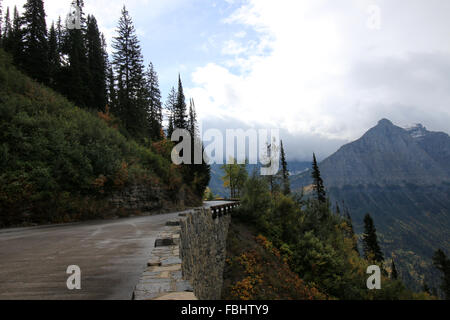 Avvolgimento stretto pericolose Wet Colorado strada di montagna che mostra brusca caduta dalla strada e picco di montagne sullo sfondo Foto Stock