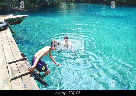 Due ragazzi di nuoto in Labuan Cermin Lago Foto Stock