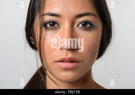 Una giovane e bella donna con capelli randagi e espressione seria e Sguardo nel vuoto Foto Stock