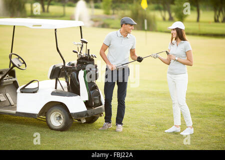 Coppia giovane a carrello da golf Foto Stock