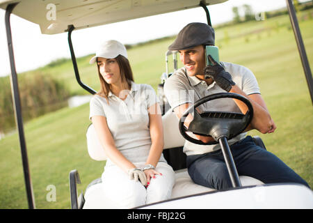 Coppia giovane a carrello da golf Foto Stock