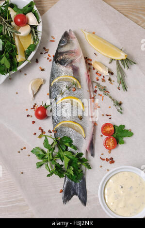 Di nuovo il Branzino con limone e le spezie e le erbe su carta Foto Stock