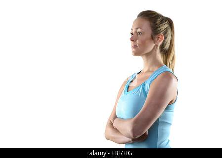 Vita Ritratto di certi Athletic donna che indossa la luce serbatoio Blu Top in piedi nella parte anteriore del grigio di sfondo per studio con bracci Foto Stock