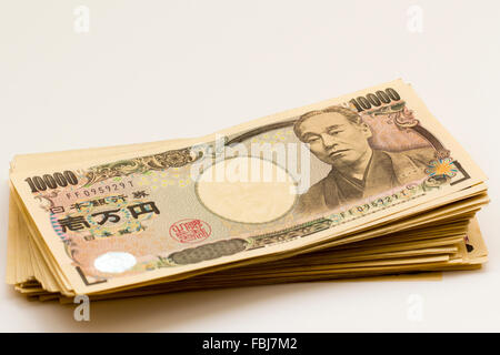 Denaro e valuta. Pila di banconote in giapponese, 10.000 yen, su sfondo bianco. Foto Stock