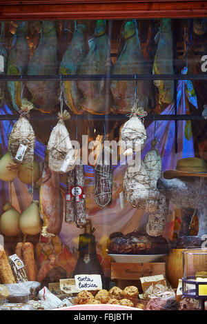 Prosciutto, salsiccia, formaggio, specialità regionali, schierati, appeso in vetrina, vista in negozio. Toscana, Italia Foto Stock