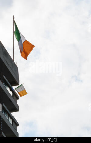 Un irlandese tricolore sventola dal repubblicano irlandese Lodge nuovi appartamenti zona di Belfast. Foto Stock