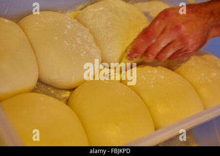 Palline di freschi fatti in casa di pasta per pizza infarinata sul pannello di legno Foto Stock