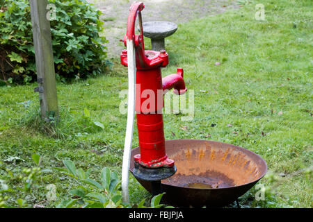 Rosso brillante pompa acqua all'esterno. Foto Stock