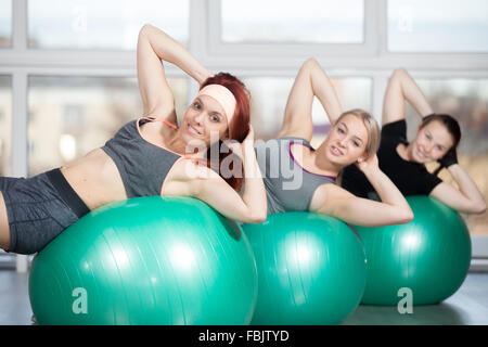 La pratica di fitness, gruppo di tre sorridenti bella montare le giovani donne che lavora fuori in un club sportivo, fare esercizio Foto Stock