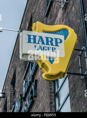 Un vecchio arpa birra lager segno su un pub di Belfast. Foto Stock