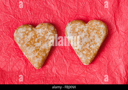 Cuore di panpepato cookie su carta rossa sfondo tabella Foto Stock