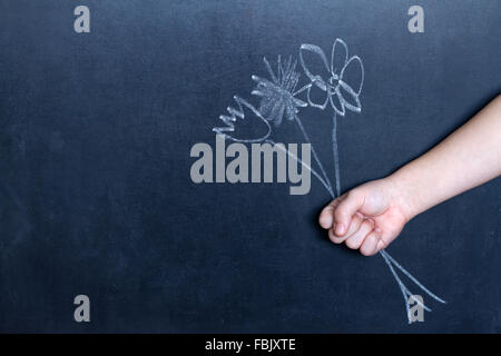 Fiori e bambino la mano di sfondo astratto concetto sulla lavagna Foto Stock