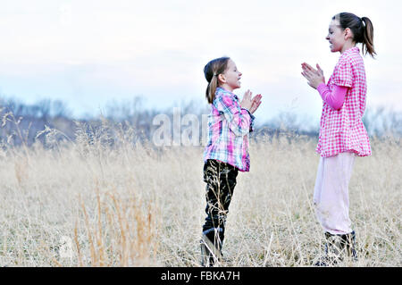 Le ragazze a giocare battendo le mani mano giochi nel campo Foto Stock