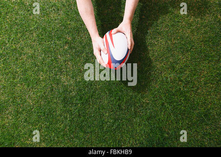 Uomo con palla da rugby di erba Foto Stock