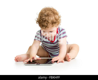 Kid boy utilizzando tablet mentre è seduto sul pavimento Foto Stock