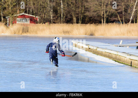 Listerby, Svezia - 17 Gennaio 2016: un ignoto ragazzo giovane è il pattinaggio con un club di hockey in giro per la marina nelle zone costiere Blekinge Foto Stock