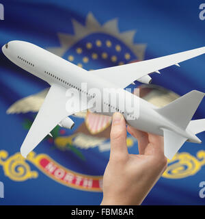 In aereo in mano con locale usa flag di stato sulla serie di sfondo - Dajota del nord Foto Stock