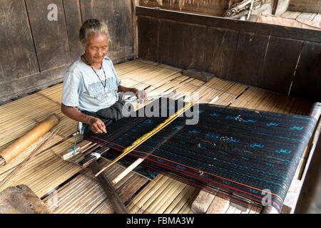 Donna anziana ikat mostrando di tessitura nel tradizionale villaggio Ngada Bena vicino a Bajawa, Flores, Indonesia, Asia Foto Stock