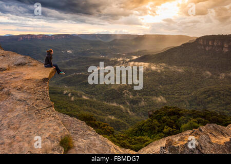 Donna seduta sulla battuta di montagna, il Parco Nazionale Blue Mountains, Nuovo Galles del Sud, Australia Foto Stock