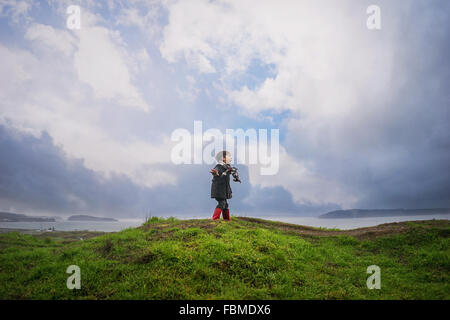 Ragazzo in piedi su una collina urlando Foto Stock