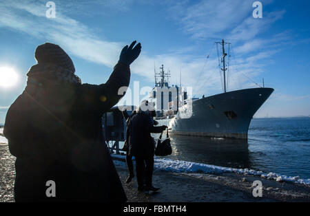 Rostock, Germania. 18 gennaio, 2016. I membri della famiglia wave come la nave di supporto 'Donau' della marina tedesca lascia la base navale di Hohe Duene a Rostock, Germania, 18 gennaio 2016. La nave di supporto, che appartiene al settimo Attacco Rapido squadrone di Artigianato della marina tedesca, entreranno a far parte della NATO permanente contromisure Mine Gruppo 1 come la sua nave ammiraglia. Il gruppo di navi dalla Gran Bretagna, Belgio, Norvegia, Danimarca e nei Paesi Bassi è di operare principalmente sul Mar Baltico. Foto: Jens BUETTNER/dpa/Alamy Live News Foto Stock