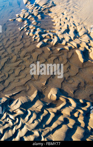 Increspata sabbia e acqua di mare su una spiaggia con la bassa marea. Regno Unito Foto Stock