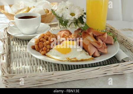 La prima colazione con uova strapazzate, pancetta, salsiccia e fagioli Foto Stock