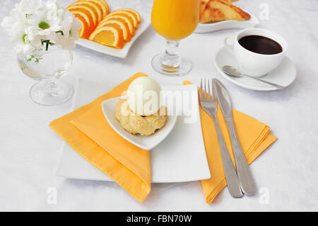 La prima colazione con uovo su sdobnoy stand con cioccolata calda e succo d'arancia Foto Stock