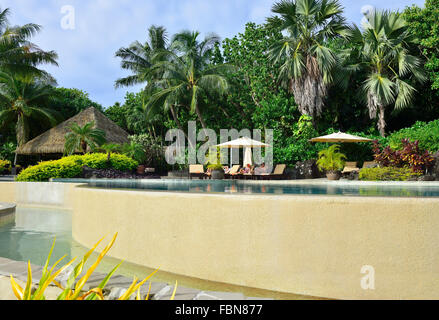 Gli ospiti si rilassano presso la piscina a sfioro del Pacific Resort sulla piccola isola tropicale di Aitutaki, Isole Cook, Sud Pacifico Foto Stock