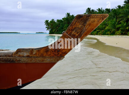 Prow di una tradizionale barca polinesiana in legno o Vaka sulla spiaggia e la laguna di tropicale un piede Isola, Aitutaki, Isole Cook Foto Stock