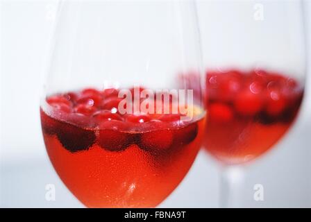 Due bicchieri con cocktail refrigerati e di mirtilli rossi freschi o di succo di mirtillo palustre e mirtilli rossi freschi. un cristallo è a fuoco. Foto Stock