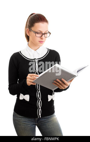 Consultazione delle note. Leggendo qualcosa. Giovane e bella ragazza dello studente con gli occhiali che guardano un notebook aperto, isolato su sfondo bianco. Foto Stock